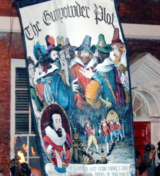 A procession banner at Lewes Bonfire Night in 2007 showing the Gunpowder Plot conspirators in colourful costume with a portrait at the bottom left, under the words The Gunpowder Plot