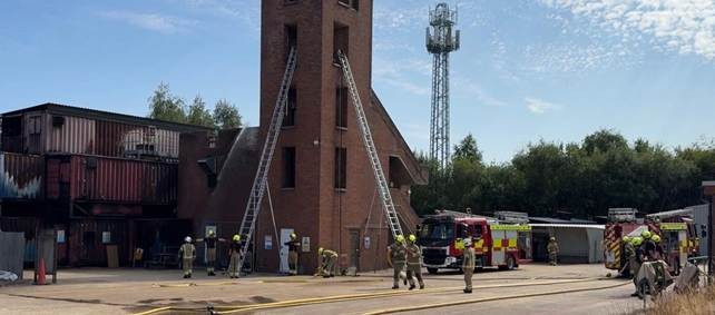 Firefighters with ladders at a training tower
