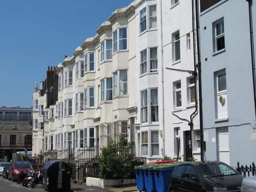 Bins in front of the white terraced houses on the north side of Clarence Square in Brighton