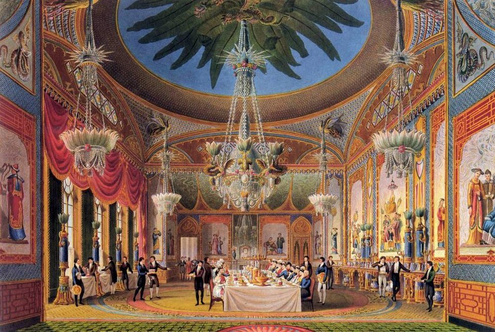 A banquet in the Banqueting Room of the Royal Pavilion in Brighton, shown in a colour print by John Nash, with a long table under a domed ceiling and a large chandelier