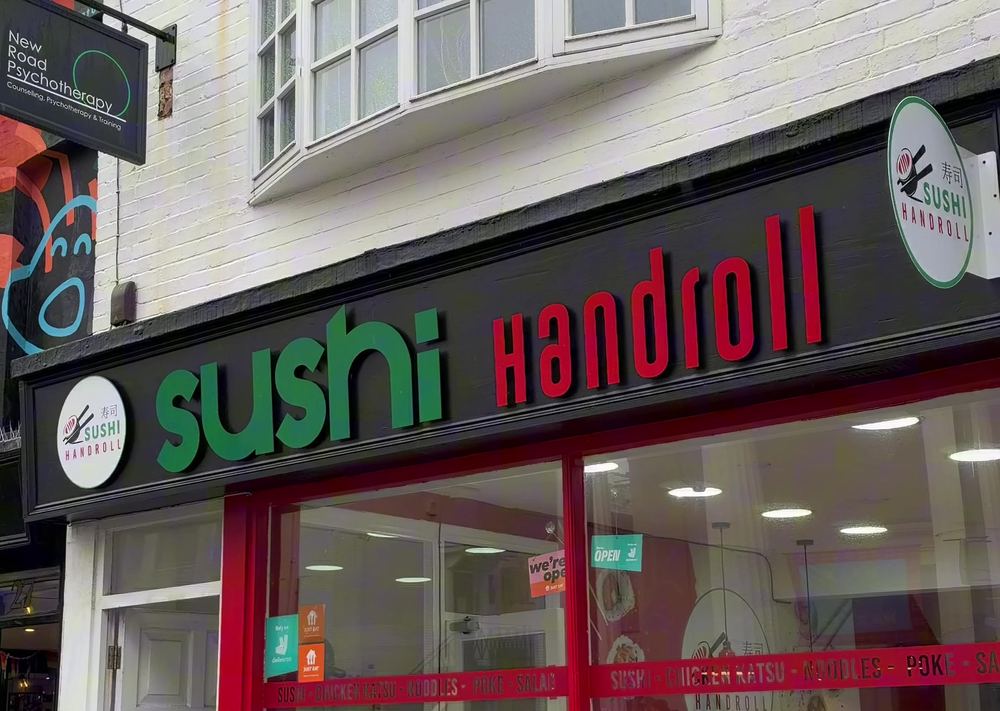 Sushi Handroll shopfront on New Road in Brighton with a black fascia, green sushi lettering and red Handroll lettering