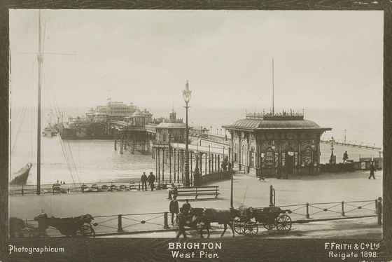Framed 1898 photograph of the West Pier from the seafront with horse-drawn carriages