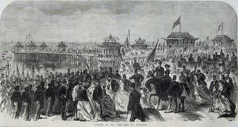 Engraving of the crowd at the opening of the West Pier in 1866 with flags and the pier behind