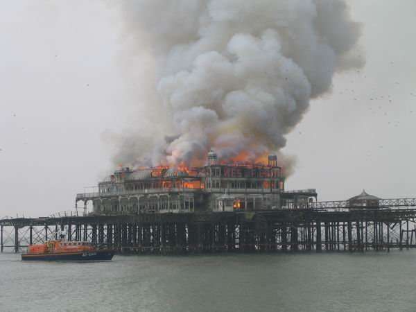 The West Pier burning in 2003 with a lifeboat in the foreground