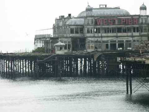 The derelict West Pier with red lettering on the building