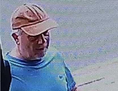 Close-up of the second CCTV image released by Sussex Police, showing a person in an orange cap