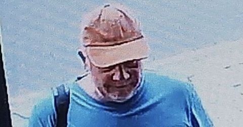 Close-up of the first CCTV image released by Sussex Police, showing a person in an orange cap and a blue T-shirt