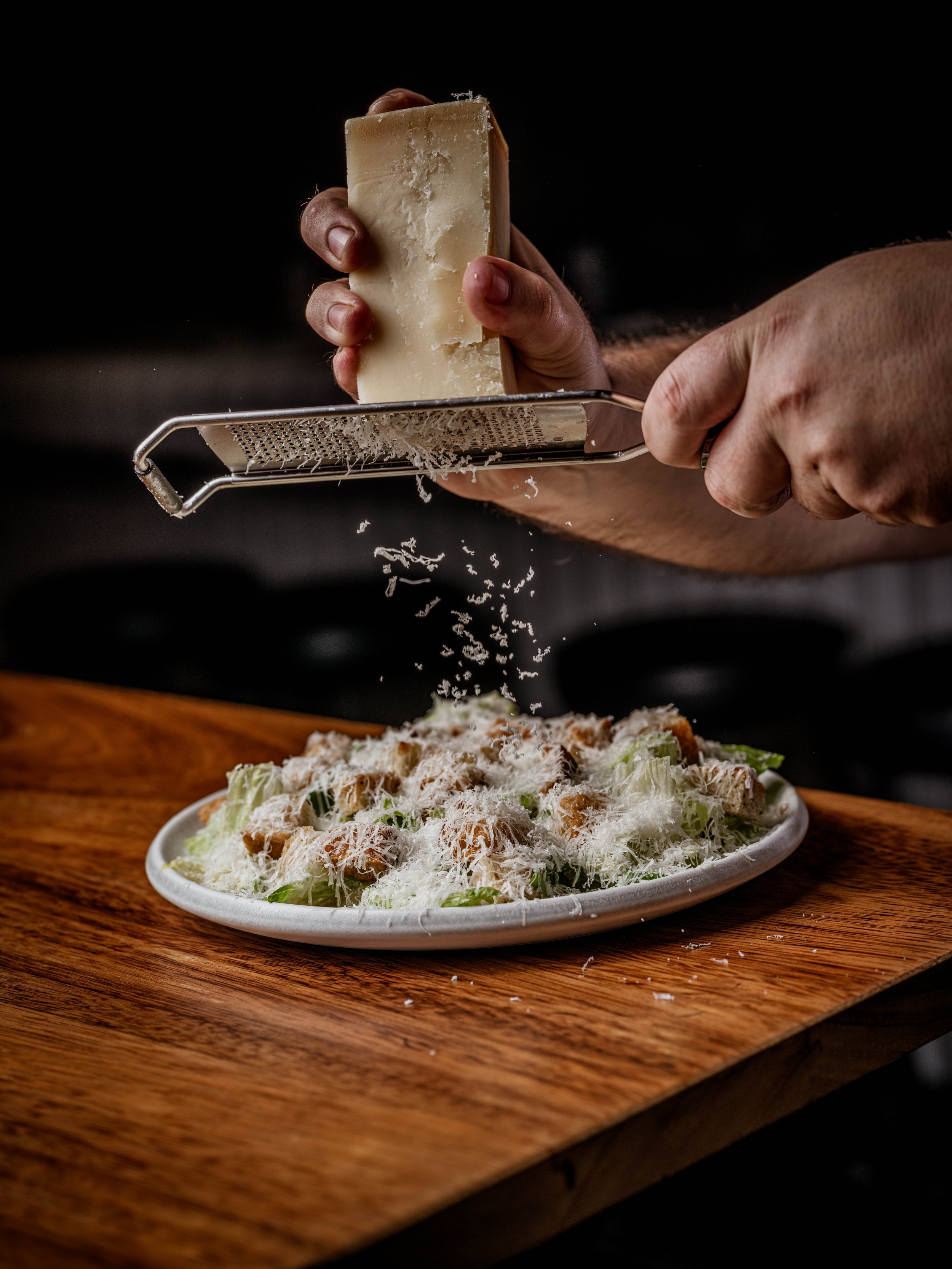 Fresh Parmesan is grated over a Caesar salad at Burger & Beyond Brighton. Photo: Burger & Beyond